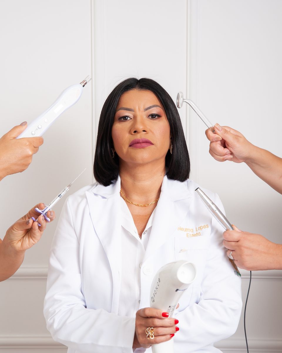 Dra. Neuma Lopes de jaleco cercada por instrumentos de estética