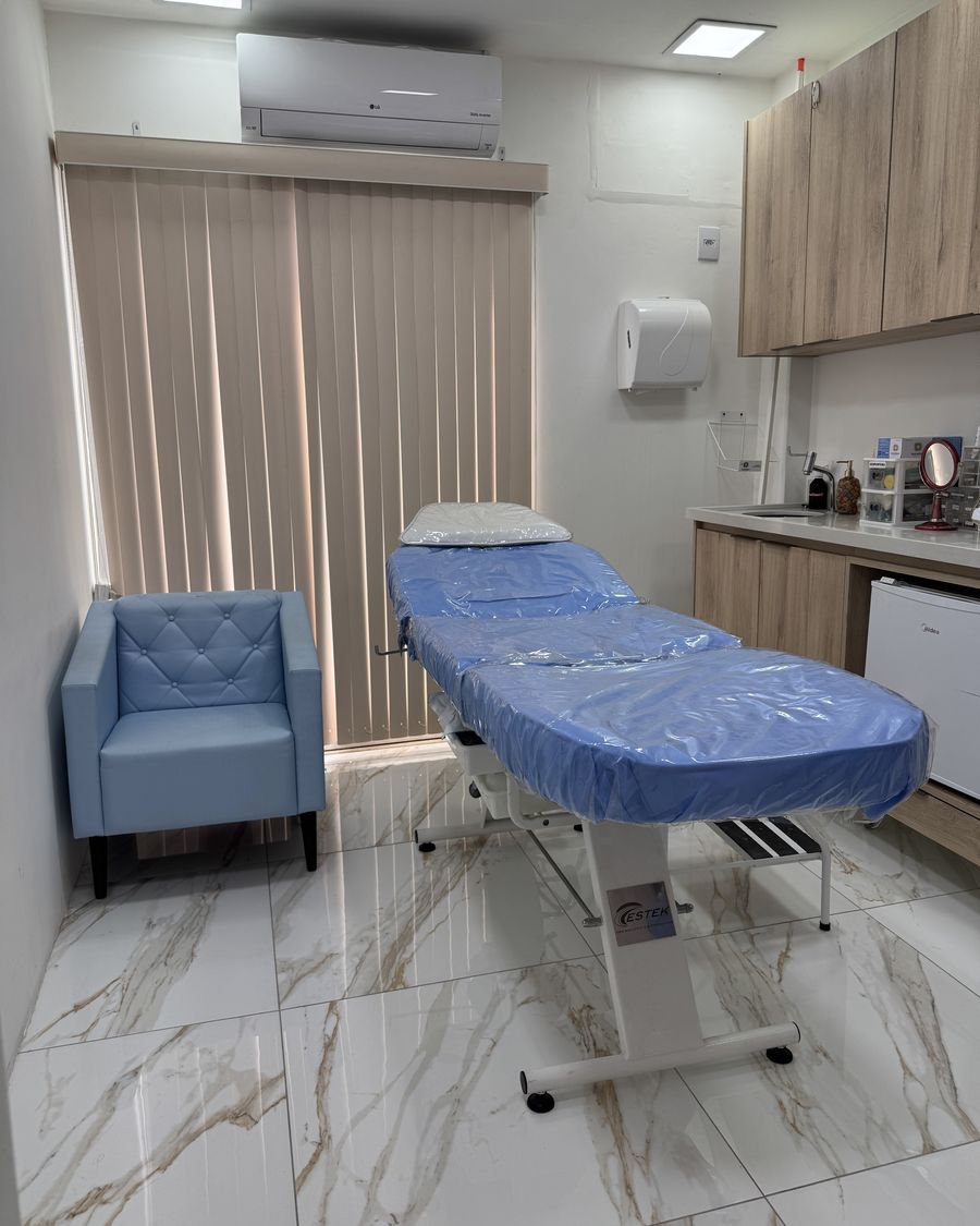 Sala de atendimento com maca e poltrona azul